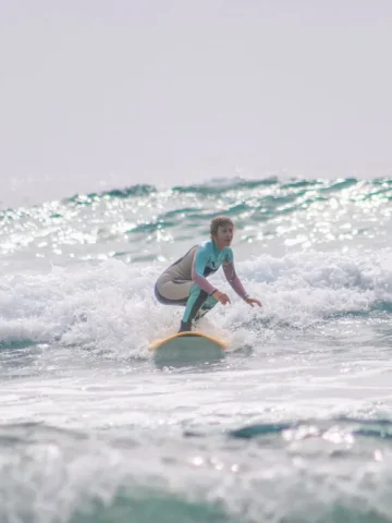 Greta surfing on a foam surfboard in Tenerife, Spain