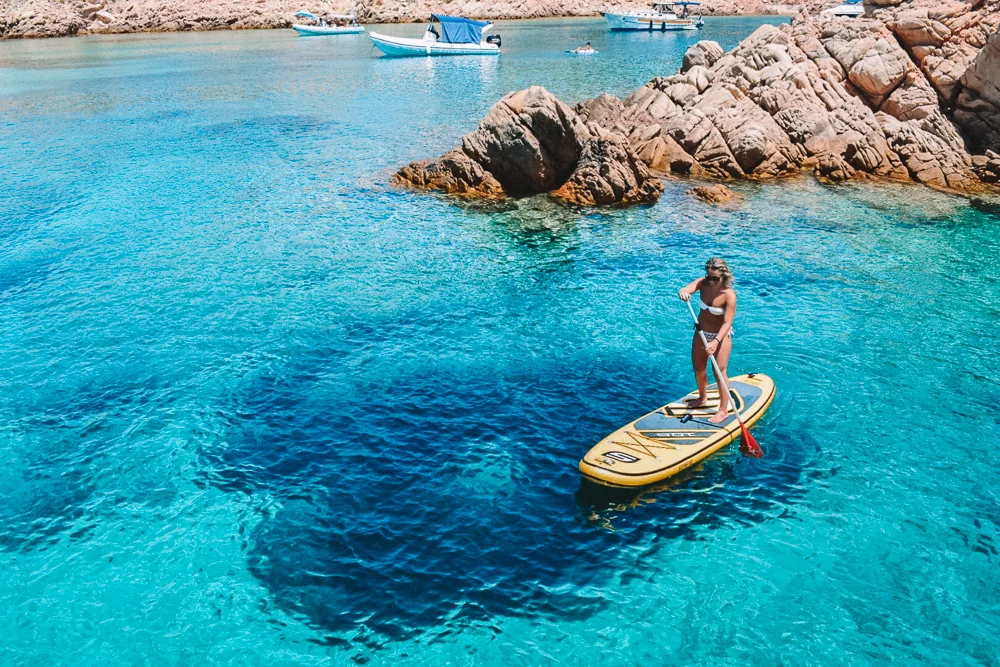 Greta doing SUP with an inflatable paddle board in Sardinia, Italy - paddle board vs surfboard, discover the difference!